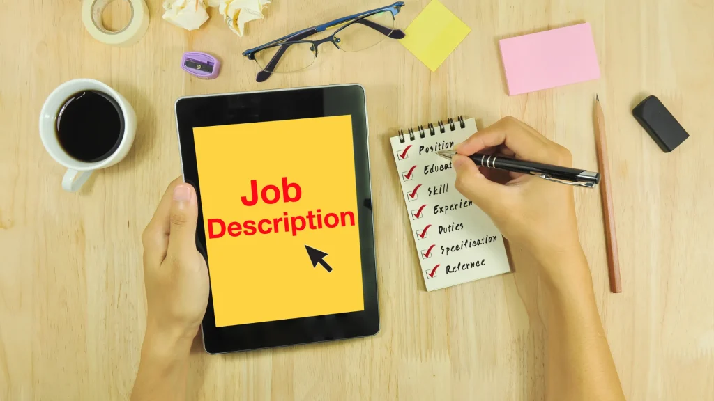 Digital Marketing Coordinator Job Description with a checklist on a notepad and tablet.