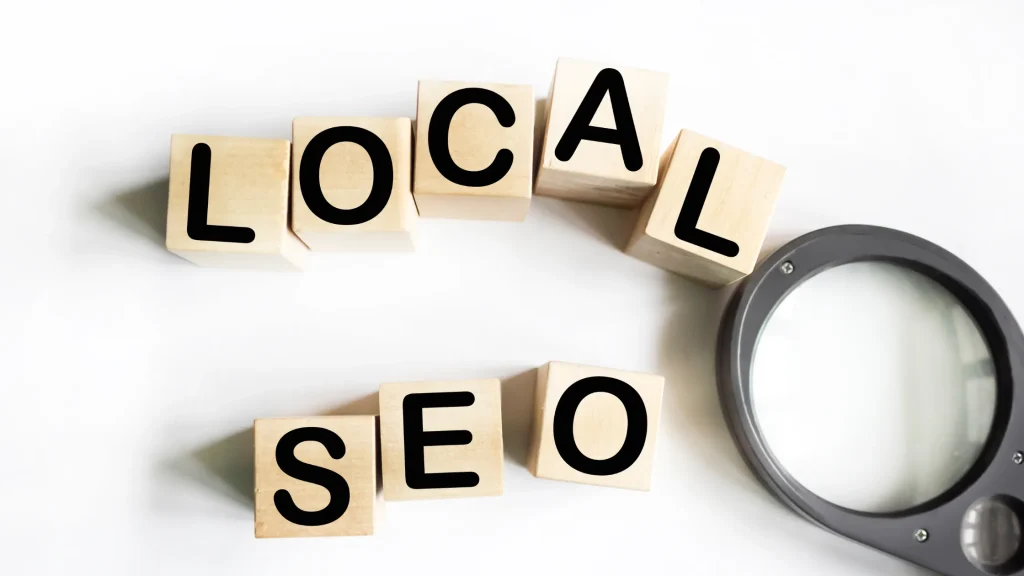 Wooden blocks spelling 'LOCAL SEO' next to a magnifying glass, representing Local SEO Agency Growmatic services.